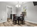 Cozy dining area with a modern light fixture, dining table with seating for four, and natural light at 402 Equinox Cir, Ladson, SC 29456