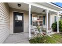Charming front porch featuring seating, white columns, and a well-maintained entrance at 402 Equinox Cir, Ladson, SC 29456