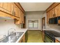 Eat in kitchen with a stainless steel sink, wood cabinets and green and yellow floor tiles at 4328 Cheviot Dr, North Charleston, SC 29418