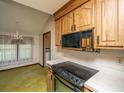 Kitchen featuring a stainless steel sink, cooktop, wood cabinets, and a dining area at 4328 Cheviot Dr, North Charleston, SC 29418