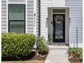 Charming front entrance with a floral wreath, well-manicured bushes and nice landscaping at 4404 Avery Ave, North Charleston, SC 29405