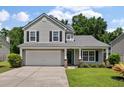 Charming two-story home featuring a well-manicured lawn, two car garage and beautiful, mature landscaping at 4977 Ballantine Dr, Summerville, SC 29485