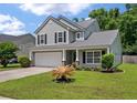 Charming two-story home featuring a well-manicured lawn, two car garage and beautiful, mature landscaping at 4977 Ballantine Dr, Summerville, SC 29485