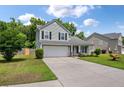 Charming two-story home featuring a well-manicured lawn, two car garage and beautiful, mature landscaping at 4977 Ballantine Dr, Summerville, SC 29485