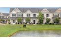 Exterior view of townhomes with pond frontage, showcasing the community's serene setting at 502 Duskywing Dr, Goose Creek, SC 29445