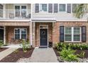 Attractive townhome entrance with a black door, brick accents, and manicured landscaping at 656 Coleman Blvd # 703, Mount Pleasant, SC 29464