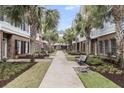 Townhome lined walkway featuring well-maintained lawns, palm trees, and seating areas at 656 Coleman Blvd # 703, Mount Pleasant, SC 29464