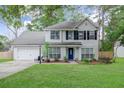 Charming two-story home with symmetrical design, black shutters and a well-manicured lawn at 709 Black Oak Blvd, Summerville, SC 29485