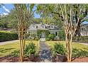 Inviting green home framed by trees, showcasing a well-manicured front yard and walkway at 735 Woodward Rd, Charleston, SC 29407