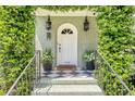 Close-up of the front door with classic lanterns, plants, and a stylish black and white tiled porch at 735 Woodward Rd, Charleston, SC 29407