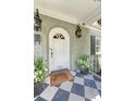 Elegant front door with brick facade, decorative lanterns, and a classic patterned porch at 735 Woodward Rd, Charleston, SC 29407