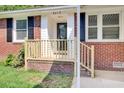 Inviting brick home with a newly constructed wooden porch and railing at 8612 Delhi Rd, North Charleston, SC 29406