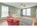 Cozy living room with light green walls, wood floors, and a colorful area rug at 8965 N Red Maple Cir, Summerville, SC 29485