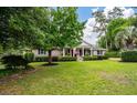 Beautiful brick home featuring a lush green lawn, mature trees, and lovely curb appeal at 102 Ashborough Ave, Summerville, SC 29485