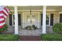 Inviting front porch with classic white columns, brick accents, and charming floral arrangements at 102 Ashborough Ave, Summerville, SC 29485