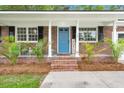 Close-up of a quaint porch with a blue front door and potted greenery, creating a cozy entrance at 105 Bermuda Ct, Summerville, SC 29485