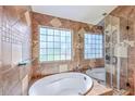 Luxurious bathroom featuring a large soaking tub with glass shower, tile flooring, and natural light at 110 Salinas Ct, Summerville, SC 29483