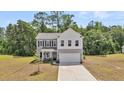 Charming two-story home featuring a two-car garage, black shutters, and a manicured front lawn at 1132 Wading Point Blvd, Huger, SC 29450