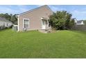 Back of the house with a well-maintained lawn and an exterior door at 120 Larkspur Dr, Goose Creek, SC 29445