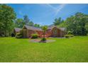 Brick home with spacious backyard, wood deck, and lush landscaping at 121 Arrowridge Ct, Summerville, SC 29485