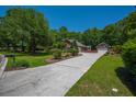 Brick home with long driveway leading to a detached garage and lush landscaping at 121 Arrowridge Ct, Summerville, SC 29485