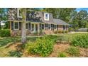 A front yard featuring a brick home, mature landscaping, and a circular driveway at 122 Mellard Dr, Goose Creek, SC 29445