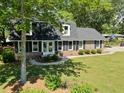 A view of a brick home with black shutters, a well-kept lawn, and attractive landscaping at 122 Mellard Dr, Goose Creek, SC 29445