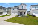 Inviting two-story home with a well-maintained lawn, attached garage, and lovely landscaping at 130 Spotted Way, Summerville, SC 29485