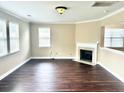 Open living room featuring hardwood floors, white trim, a fireplace and windows with wooden blinds at 1333 Song Sparrow Way, Hanahan, SC 29410