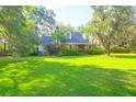 Inviting single-Gathering home featuring brick facade, well-manicured lawn, and mature shade trees at 1521 Wren Ave, Mount Pleasant, SC 29464