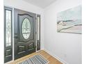 Elegant entryway with a black front door with glass inlays and a decorative rug on wood flooring at 1655 Pinckney Park Dr, Charleston, SC 29407