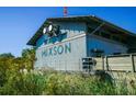 Mixon's galvanized metal exterior is surrounded by a wooden fence and tropical plants at 1671 Indy Dr, North Charleston, SC 29405