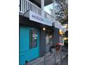 Mixon Market Storefront featuring a teal entry door, a sandwich board, and a second story balcony at 1671 Indy Dr, North Charleston, SC 29405
