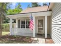 Inviting front porch with classic columns and an American flag, offering a warm welcome at 172 Ashton Dr, Goose Creek, SC 29445