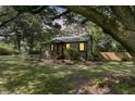 Charming home with mature shade trees and a red front door in a well-maintained yard at 1730 Harrison Ave, Charleston, SC 29407