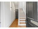 Inviting home foyer with wooden floors, white walls, a staircase, and a door leading to another room at 19 Smith St # B, Charleston, SC 29401