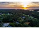Sunset aerial view of 200 Belted Kingfisher surrounded by beautiful trees and landscape at 200 Belted Kingfisher Rd, Kiawah Island, SC 29455