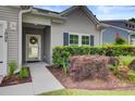Well-manicured bushes and landscaping highlight the front entryway of this light gray house at 2008 Welsh Pony Dr, Mount Pleasant, SC 29429