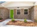 Close-up of home's front porch with a bright green door and mature landscaping at 205 Owens Dr, Summerville, SC 29485