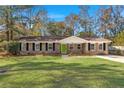 Charming brick home featuring a lush green lawn and a vibrant green front door at 205 Owens Dr, Summerville, SC 29485