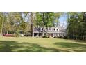 Exterior view of a charming house, displaying its well-manicured lawn and surrounded by a beautiful array of trees and shrubs at 206 Chaussee Blvd, Summerville, SC 29483