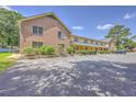 Apartment complex featuring brick facade, a covered porch, and ample parking space for residents and visitors at 2150 Spoleto Ln # H2, North Charleston, SC 29406