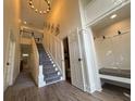 Inviting home foyer featuring a staircase, a modern light fixture, and a convenient mudroom area at 2204 Andover Way, Mount Pleasant, SC 29466