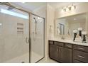 Modern bathroom with a glass-enclosed shower, marble tiles, and a sleek dark vanity at 2476 Grange Cir, Summerville, SC 29486