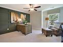 Elegant home office featuring panelled walls, a wooden desk, and comfortable seating area at 2476 Grange Cir, Summerville, SC 29486