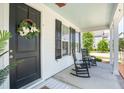Relaxing front porch with rocking chairs, complemented by a decorative wreath on the front door at 262 Great Lawn Dr, Summerville, SC 29486
