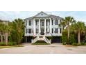 Stately two-story home featuring a welcoming front porch with columns, dual garage doors, and manicured landscaping at 2705 Parkers Landing Rd, Mount Pleasant, SC 29466