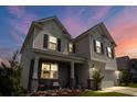 Exterior view of home at dusk, showing welcoming front porch and attached garage at 2746 Sunrose Ln, Johns Island, SC 29455