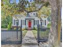 Inviting home featuring a red front door, black shutters, and a walkway leading to the entrance at 318 N Magnolia St, Summerville, SC 29483