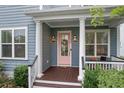 Inviting front porch with classic columns, pink door, and well-maintained landscaping for a welcoming entrance at 410 Eliston St, Summerville, SC 29486